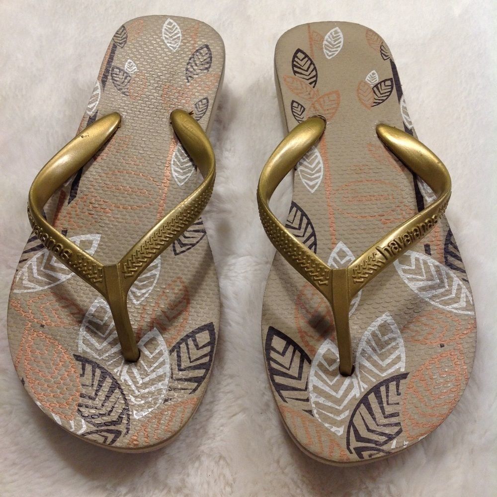 Havaianas flip flops in gold and tan.